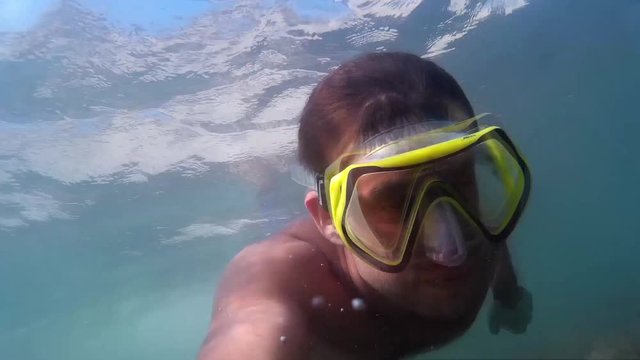 Man swimming underwater. Diving on the Black Sea. Man plunges into the sea.  Go-Pro video.  Diving, man dives and swims under water.  Marine dive, active, bright impressions. Go-Pro video.  