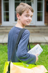 Portrait Of Teenage Boy Delivering Newspaper To House