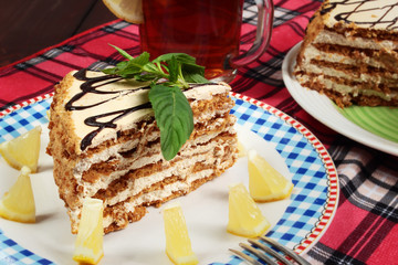 sweet cake with cup of tea end lemon on wooden table