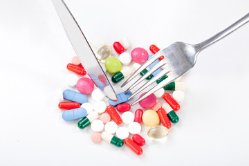 Drugs, medicine in a dish with fork and knife