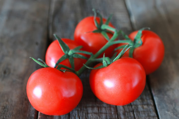 branch of tomatoes on wooden background