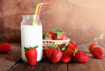 wooden table with strawberries and milk in a glass
