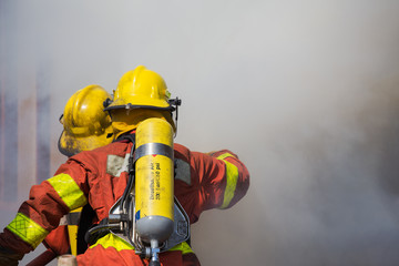 firefighter and rescue team surround with smoke and dust in academy training