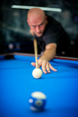 Young man playing pool game in pub