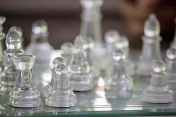 Transparent chess made fo glass on wood background , Focus sharp specific point