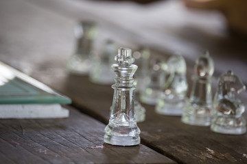 Transparent chess made fo glass on wood background , Focus sharp specific point