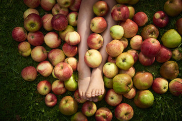 Children's feet hidden in a pile of apples