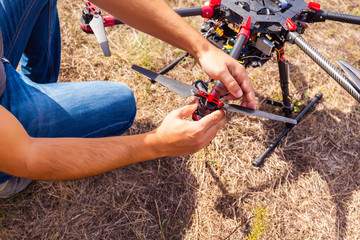 The process of setting up a copter before flight. The man makes all the necessary adjustments before the flight on the drone.