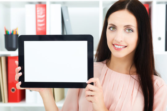 Portrait of a young secretary holding a tablet with empty screen for text or picture.