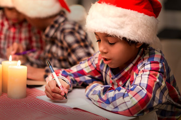 Little Santa writes a letter. Christmas kid writing letter. Congratulating pen-friends on...