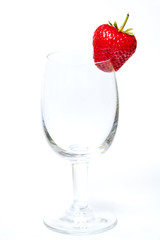 Red and ripe strawberry in wineglass on a white background