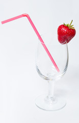 Red and ripe strawberry on the glass with tube