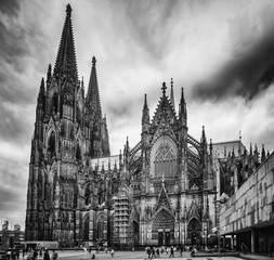 The historical Dom of Köln in Germany in black and white with clouds on the background.