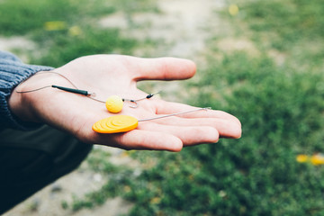 Man hands holding fishing baits. Natural bait. The bait for carp, catfish. Fisher puts bait on the hook.