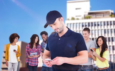 Composite image of smiling man using mobile phone 