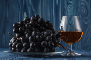 Cognac glass with grape on table
