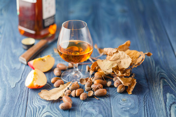 Snifter glass with amber colored brandy on a grunge wooden table