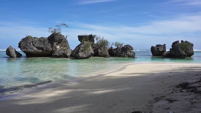 Eroded limestone rocks formation in the lagoon seen from a sandy beach, Rurutu island, Pacific ocean, Austral archipelago, French Polynesia
