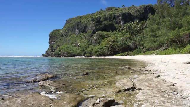 Coastal landscape of Rurutu island, beach with eroded limestone cliff on the shore, south Pacific ocean, Austral archipelago, French Polynesia
