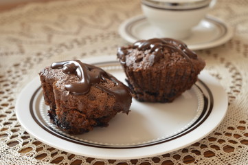 Homemade chocolate muffins heart shaped with chocolate glaze on white plate
