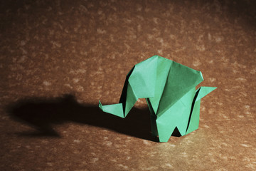 Cute origamis art, colored animals shapes isolated over a wooden background