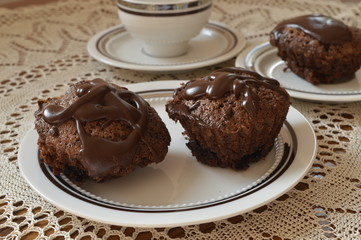 Homemade chocolate muffins heart shaped with chocolate glaze on white plate
