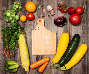 Vegetables and ingredients for cooking around cutting board 