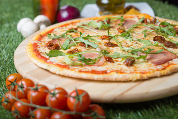 Delicious pizza with rucola, italian ham and sun dried tomatoes. 