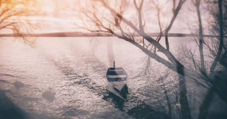 Moored boat on lake shore. Dreamy picturesque scene. Tilt shift effect.