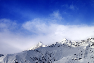 Fototapeta na wymiar Snow sunlight mountain peak in fog and blue sky
