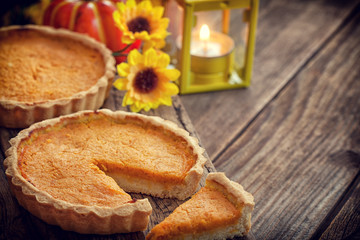 Thanksgiving pumpkin pie with lantern on wooden background