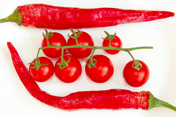 cherry tomatoes and pods of chili peppers isolated