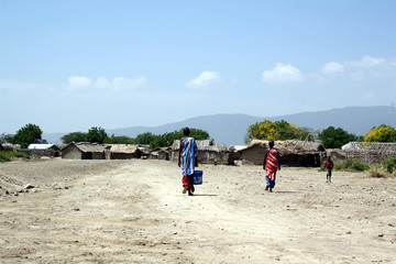 Ethnic Chaga villagers of Mikocheni, Moshi area, Tanzania, walking near their traditional clay huts