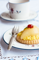 Mini Gingered Pear Tart, garnished with candied cherry and lemon balm leaf