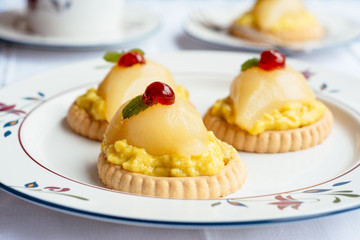 Mini Gingered Pear Tarts, garnished with candied cherry and lemon balm leaf