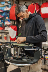 Stringing Machine. Tennis stringer doing racket stringing in his workshop