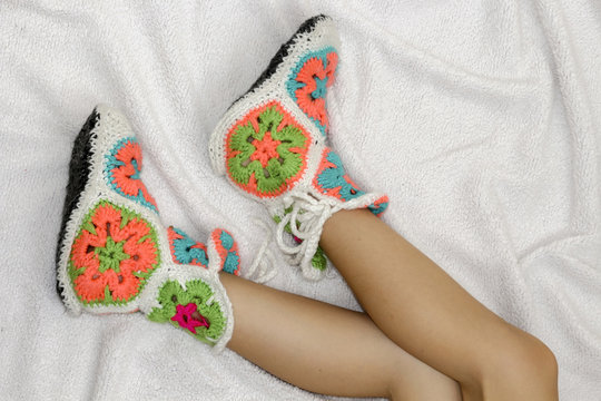 The woman's legs in socks on the rug .Vintage Warm knitted socks, handmade.