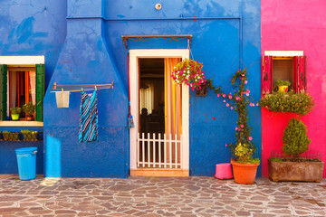 Fototapeta na wymiar Exterior of colorful houses of Burano Island in Venice.Windows,walls,laundries,flowers and even umbrellas reflects the culture of the people in the island.