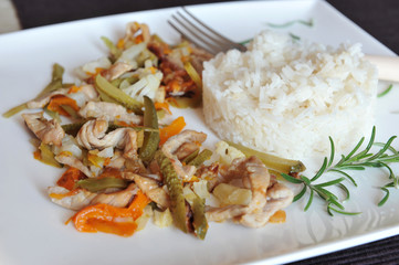 Rice decorated with rosemary twig and vegetables on a white plat