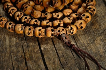 religious rosary of skulls of sandalwood on an old table, closeup
