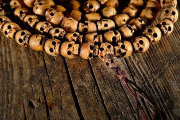 religious rosary of skulls of sandalwood on an old table, closeup
