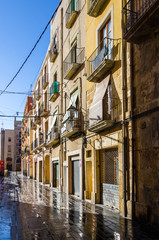 Fototapeta na wymiar Wet sunny street early morning in Tarragona, Spain
