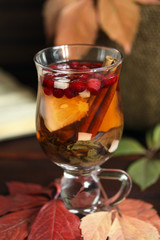 Autumn tea with lemon, spices in glass cup closeup