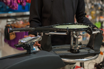Stringing Machine. Tennis stringer doing racket stringing in his workshop