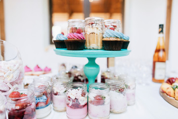 Delicious wedding reception candy bar Dessert table for a wedding  party. Cakes with raspberries and strawberry jam