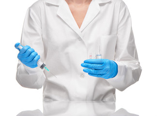 Doctor holding medical syringe and glass ampoules with drug