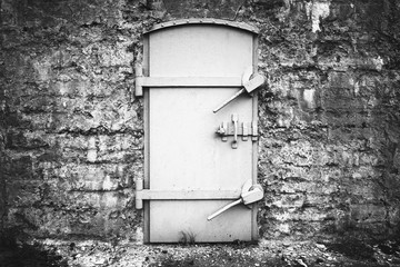 Locked metal door in old fortification wall