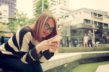 Young asian woman enjoy with social online connection on mobile smartphone outdoors, asian girl lifestyle