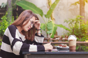 People lifestyle technology, young asian girl using smartphone while relax with coffee and cake on table