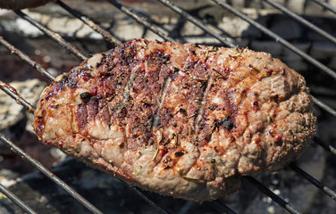 Grilled beef steak cooking on barbecue grill